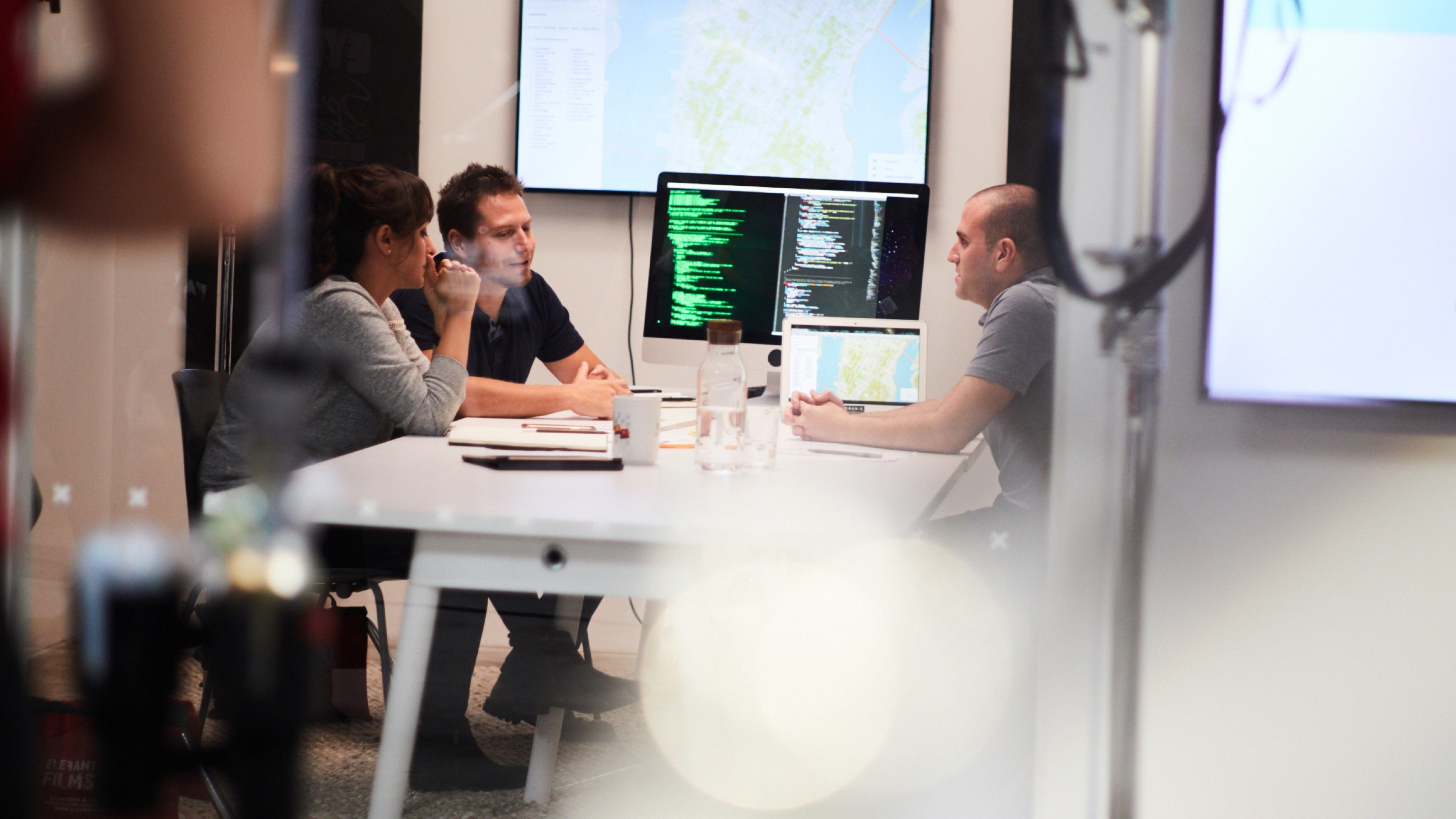 Three people have a discussion at Urban X.